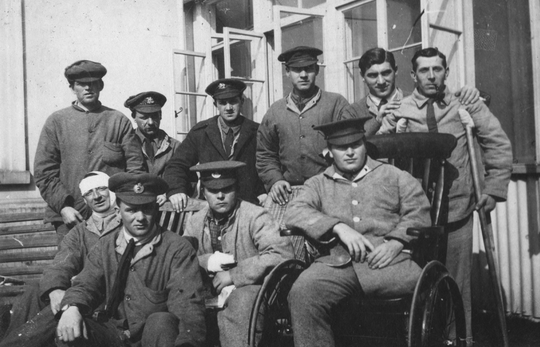 A group of injured soldiers including some with wheelchairs, crutches.